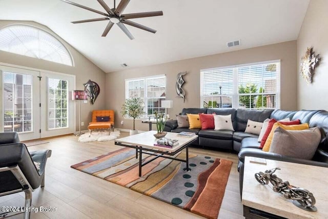 living room featuring ceiling fan, vaulted ceiling, and light wood-type flooring