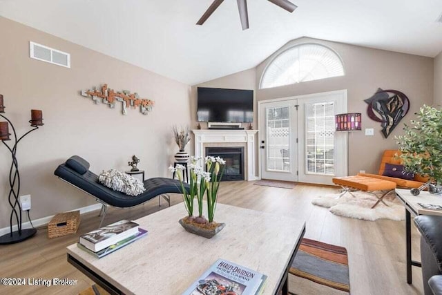 living room with hardwood / wood-style floors, ceiling fan, and high vaulted ceiling