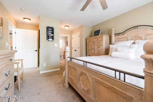 bedroom with ensuite bath, ceiling fan, and light colored carpet