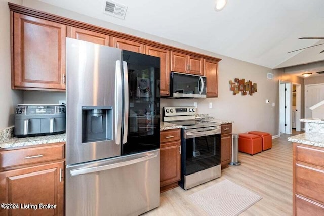 kitchen featuring light wood-type flooring, stainless steel appliances, light stone counters, and ceiling fan