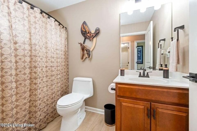 bathroom featuring vanity, wood-type flooring, and toilet