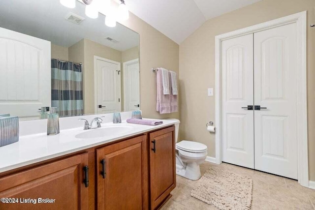 bathroom with tile patterned floors, vanity, toilet, and lofted ceiling