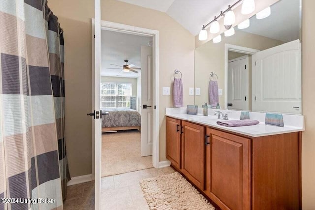 bathroom with tile patterned floors, ceiling fan, vanity, and lofted ceiling