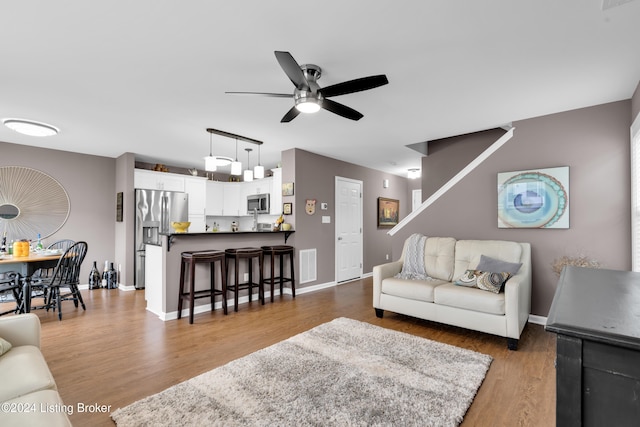 living room featuring ceiling fan and dark hardwood / wood-style flooring