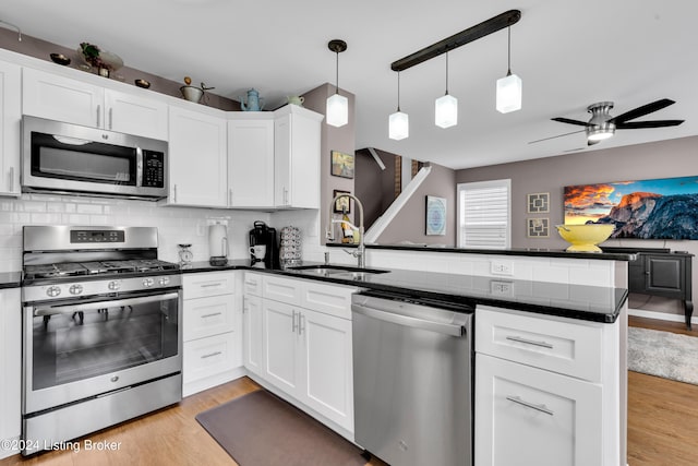 kitchen featuring kitchen peninsula, white cabinets, and appliances with stainless steel finishes