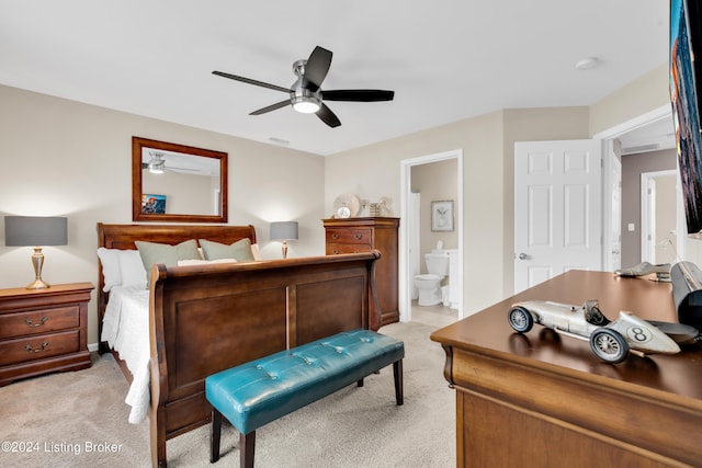 carpeted bedroom with ensuite bath and ceiling fan