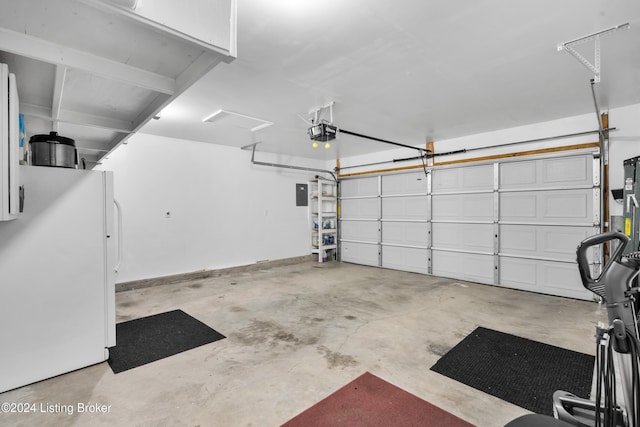 garage featuring white fridge and a garage door opener