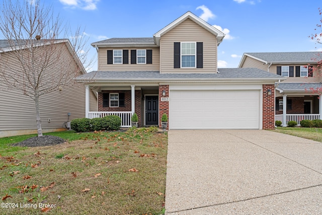 view of front of house with covered porch, a front yard, and a garage