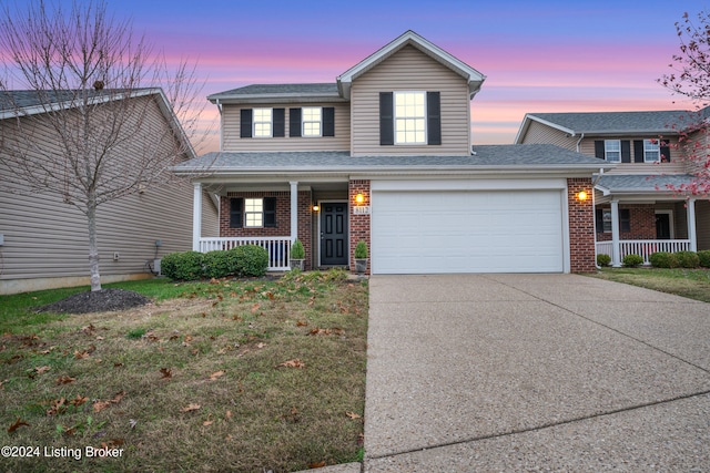 view of front facade with a lawn, a porch, and a garage