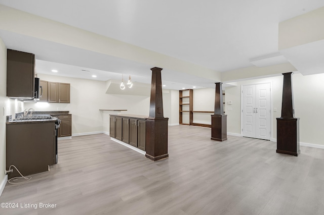 kitchen with light wood-type flooring and ornate columns