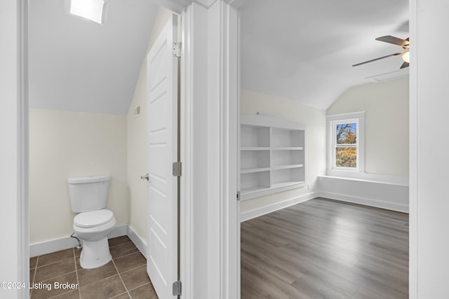 bathroom featuring vaulted ceiling, hardwood / wood-style flooring, built in shelves, ceiling fan, and toilet