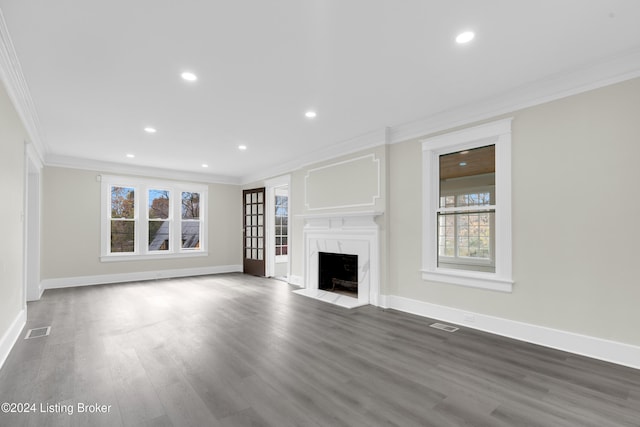 unfurnished living room featuring a wealth of natural light, a high end fireplace, dark wood-type flooring, and ornamental molding