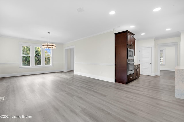 unfurnished living room with ornamental molding, a notable chandelier, and light wood-type flooring