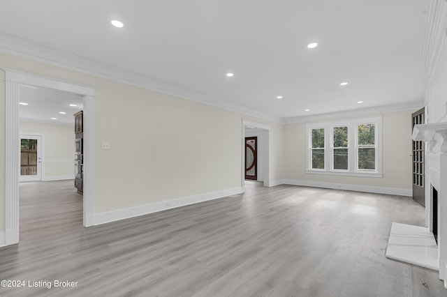 unfurnished living room with light wood-type flooring and crown molding