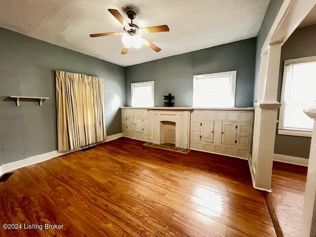 unfurnished bedroom with hardwood / wood-style flooring, multiple windows, and ceiling fan