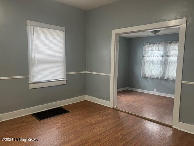 unfurnished room with hardwood / wood-style flooring