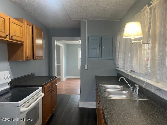 kitchen with sink, dark wood-type flooring, a textured ceiling, and white electric range