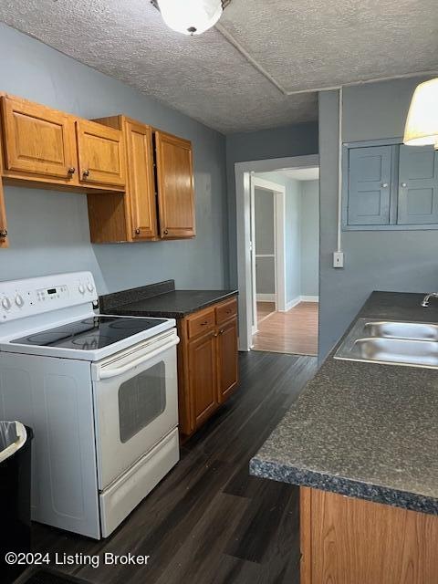 kitchen with white range with electric cooktop, sink, dark wood-type flooring, and a textured ceiling