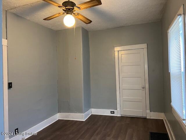 spare room with ceiling fan, dark hardwood / wood-style flooring, and a textured ceiling