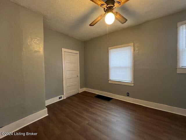 spare room featuring ceiling fan, dark hardwood / wood-style flooring, and a textured ceiling