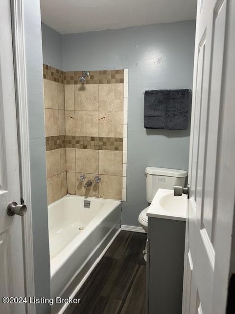 full bathroom featuring vanity, tiled shower / bath, wood-type flooring, and toilet