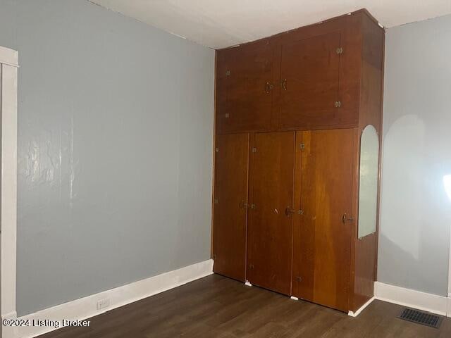 unfurnished bedroom with dark wood-type flooring