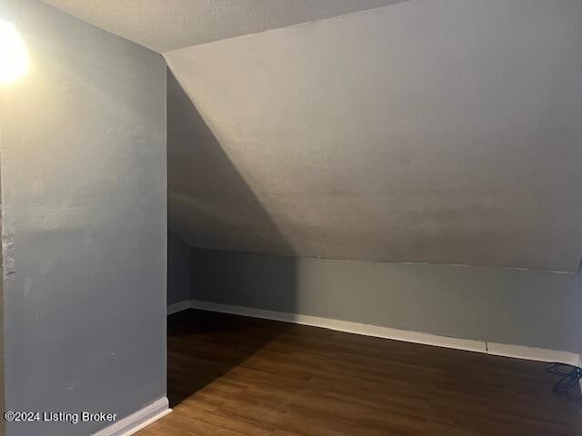 bonus room featuring dark hardwood / wood-style flooring and vaulted ceiling