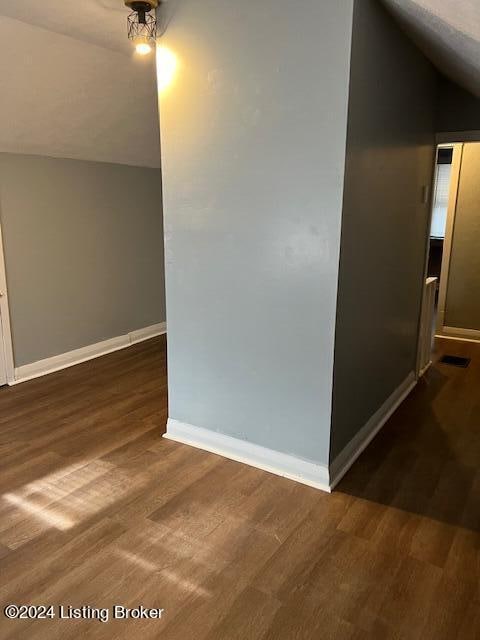 interior space featuring dark hardwood / wood-style flooring and lofted ceiling