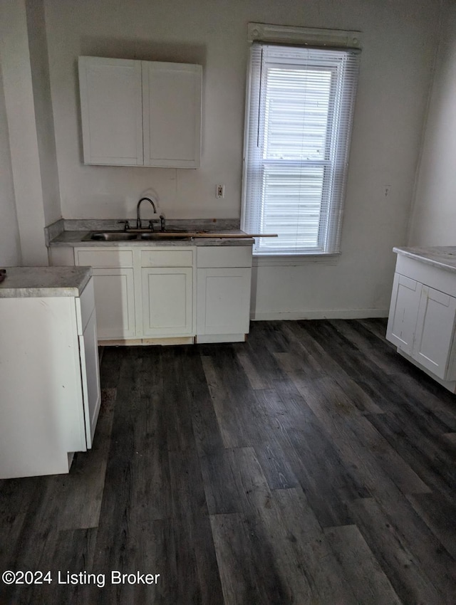 kitchen featuring dark hardwood / wood-style flooring, white cabinetry, and sink