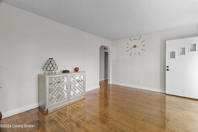 empty room with wood-type flooring and a textured ceiling