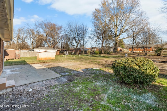 view of yard with a playground, a patio, and a shed