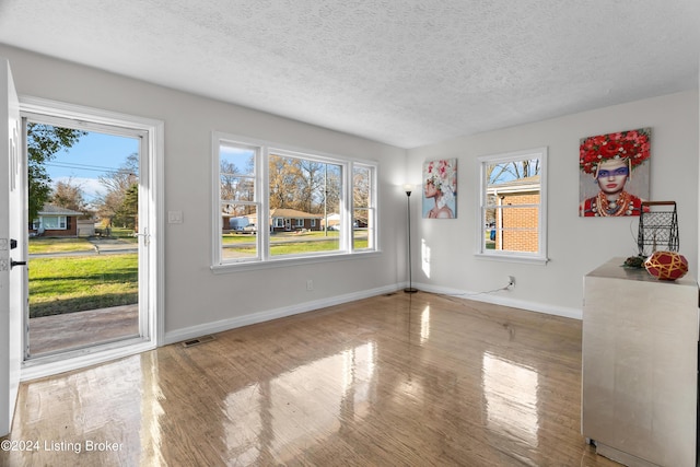 empty room featuring a textured ceiling and hardwood / wood-style flooring