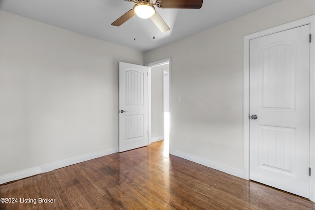 unfurnished bedroom featuring dark hardwood / wood-style floors and ceiling fan