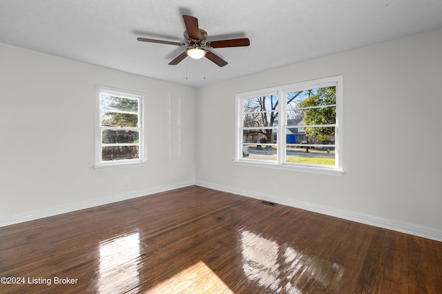 spare room with dark hardwood / wood-style floors and ceiling fan