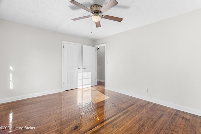 unfurnished bedroom with ceiling fan, a textured ceiling, and hardwood / wood-style flooring