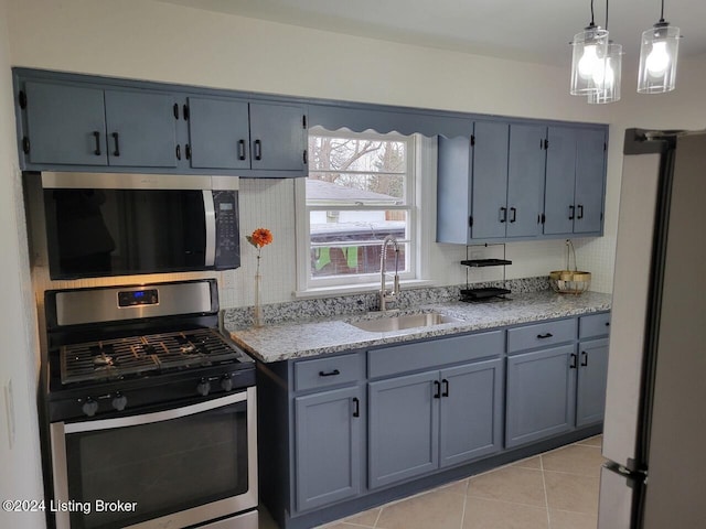 kitchen with light stone countertops, sink, stainless steel appliances, decorative light fixtures, and light tile patterned floors