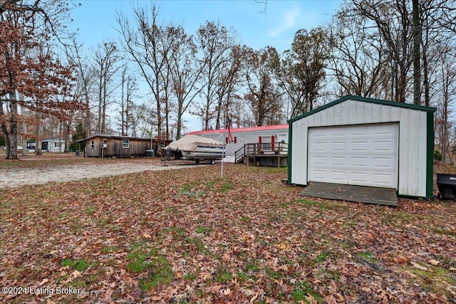 view of yard featuring a wooden deck, an outdoor structure, and a garage