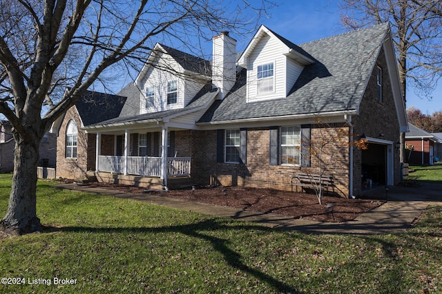 new england style home with a garage, covered porch, and a front yard