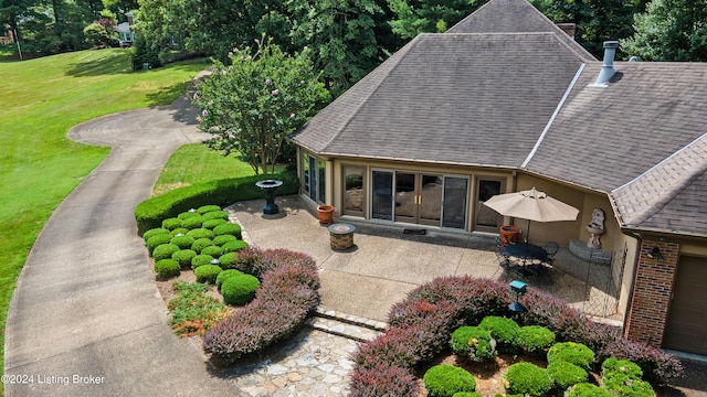 back of property featuring a patio area and a yard