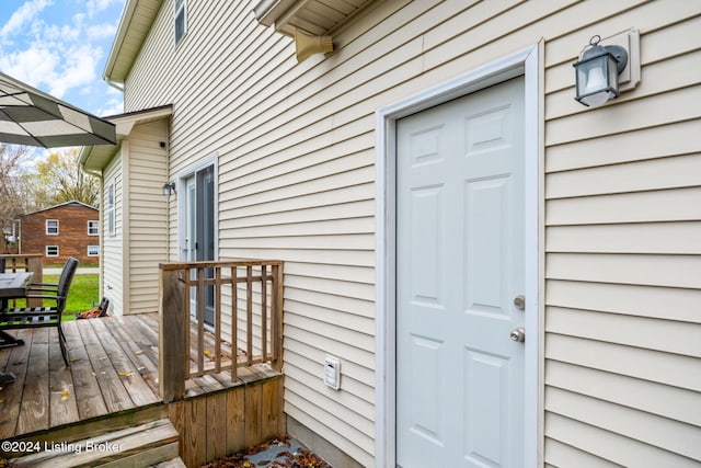 view of exterior entry with a wooden deck