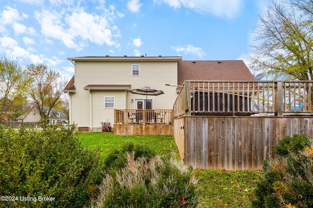 back of house featuring a yard and a wooden deck