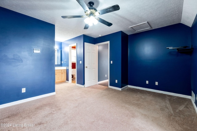 unfurnished bedroom with connected bathroom, ceiling fan, light colored carpet, and vaulted ceiling