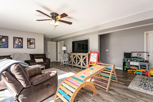 living room featuring ceiling fan and dark hardwood / wood-style flooring