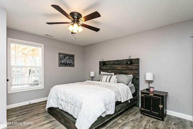 bedroom with dark hardwood / wood-style floors and ceiling fan