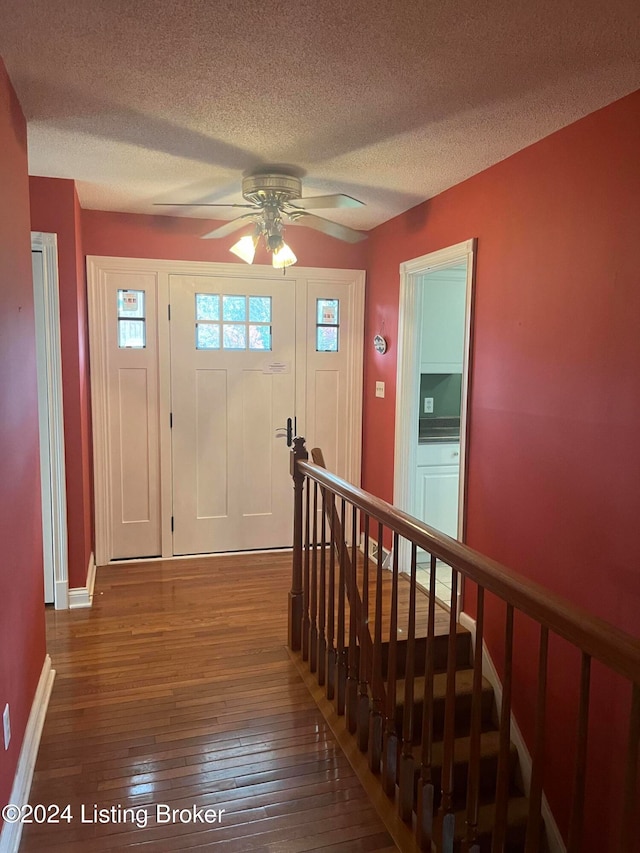 foyer with a textured ceiling, dark hardwood / wood-style floors, and ceiling fan