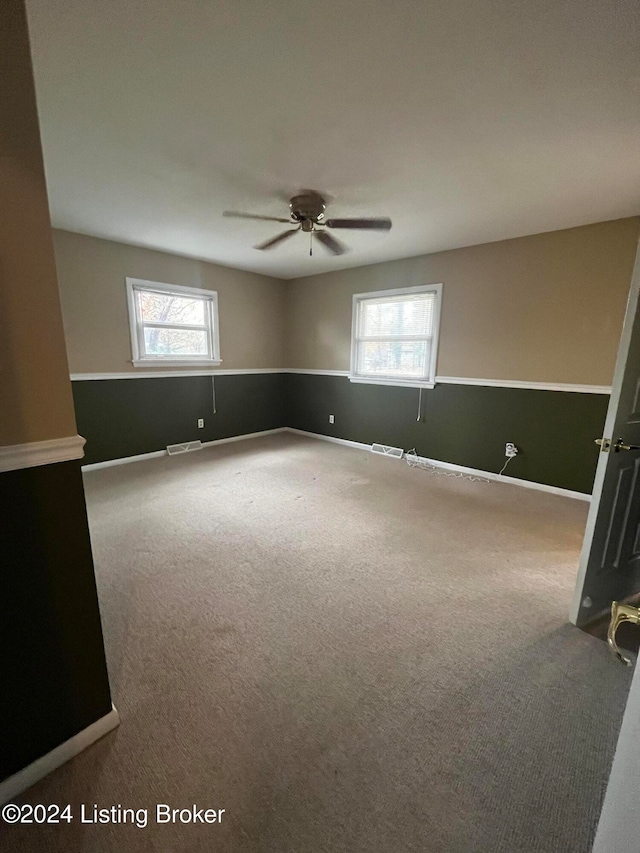 empty room with ceiling fan and carpet floors