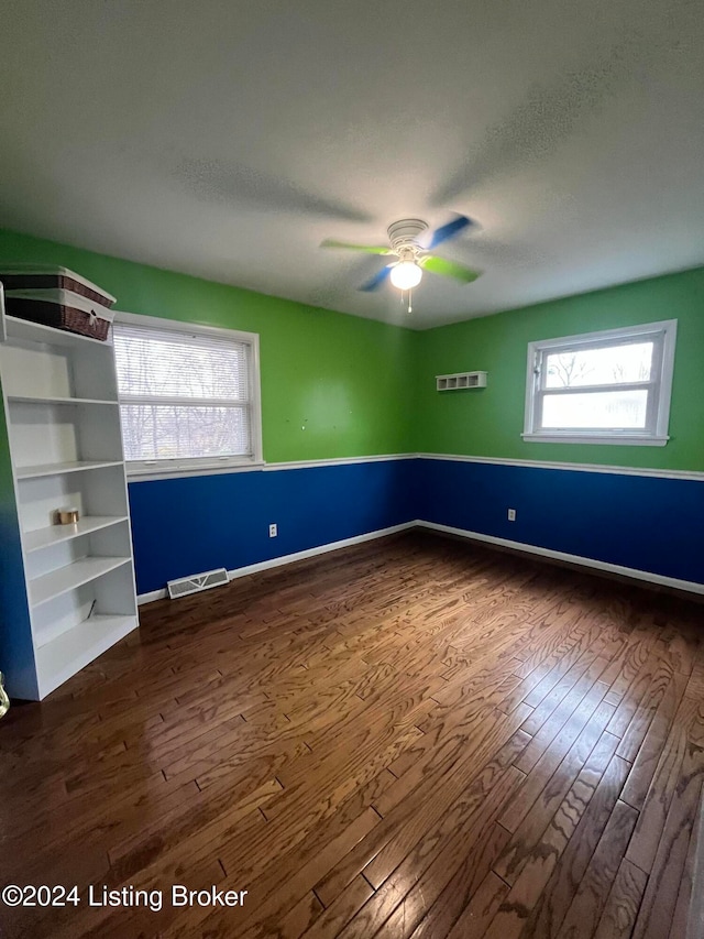 spare room with a textured ceiling, dark hardwood / wood-style flooring, and ceiling fan