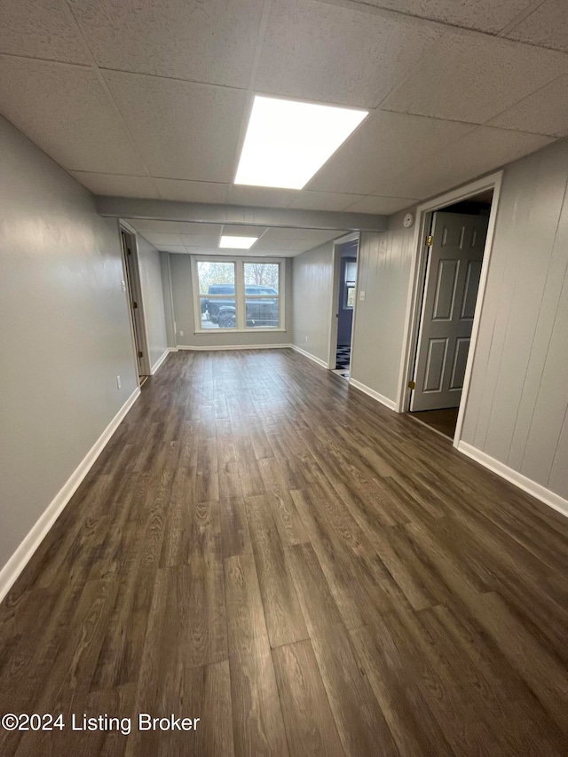 interior space featuring a paneled ceiling and dark hardwood / wood-style flooring