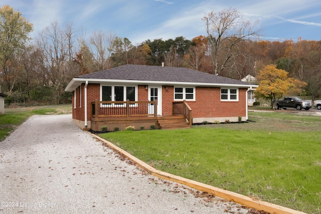 view of front of home with a wooden deck and a front yard