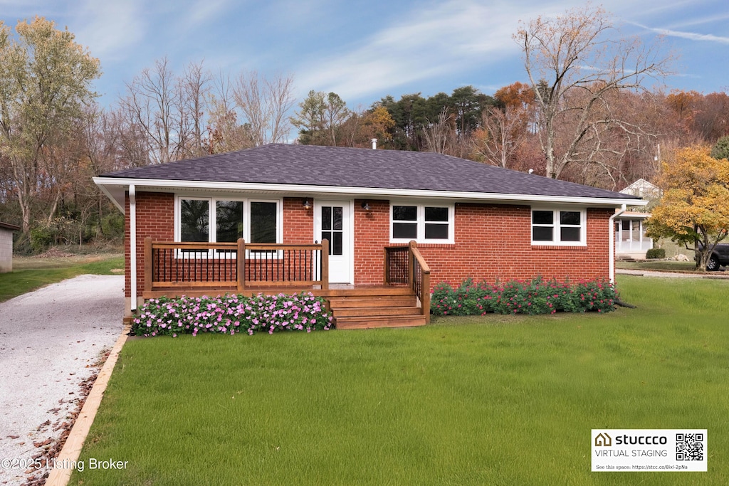 ranch-style home with a deck and a front lawn